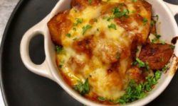 Baked Spicy Potatas Bravas topped with melted trio cheese